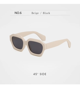 Détail de lunettes de soleil hexagonales beiges à monture épaisse avec verres foncés à 45°