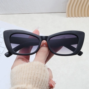 Detail of matte black cat eye sunglasses featuring purple gradient lenses and retro frame
