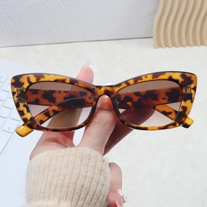 Detail of tortoiseshell cat eye sunglasses featuring brown gradient lenses and resin frame