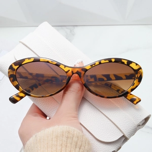 Retro tortoiseshell oval sunglasses with brown lenses and white leather folding case