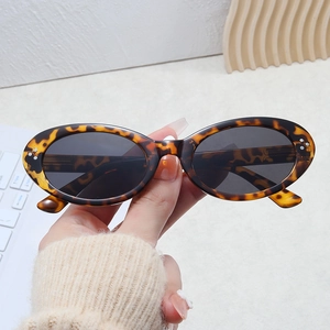 Vintage tortoiseshell oval sunglasses with silver dot accents and dark UV lenses