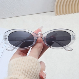 Macro detail of retro oval sunglasses with transparent acrylic frames and dark lenses