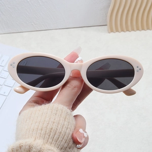 Close-up of retro oval sunglasses in cream resin with silver metal rivets details