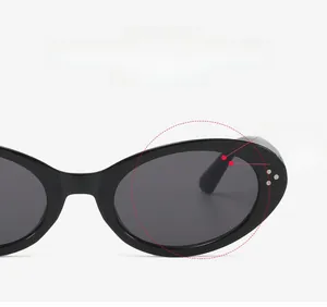 Detail of vintage cat-eye sunglasses featuring black frame with silver metal rivets