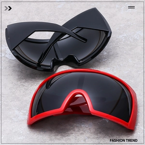Detail of oversized wraparound fashion sunglasses in glossy black and vibrant red finishes