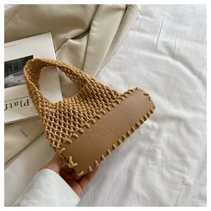 Close-up of bohemian woven cotton bag featuring a reinforced brown leather base and stitch detail