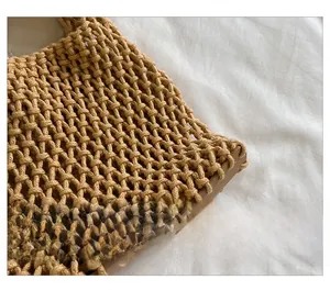 Macro view of detailed hollow mesh weave on a khaki handmade cotton cord shoulder bag