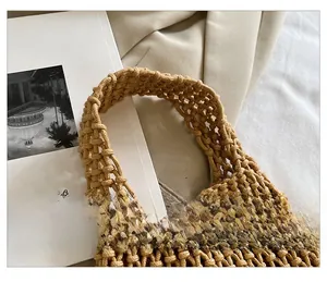 Detailed close-up of the woven cotton rope handle and handmade knot craft on a tan tote bag