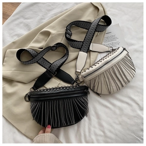 Detail of studded leather chest bags with metallic tassels and chevron wide straps