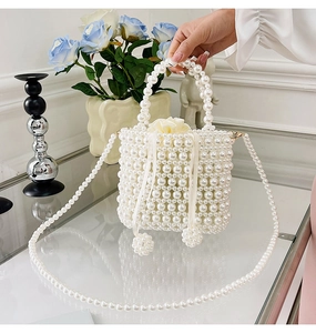 Détail du sac seau perlé fait main avec doublure en satin et bandoulière en chaîne