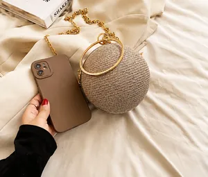 Sparkling rhinestone ball-shaped evening bag shown next to a smartphone for size comparison