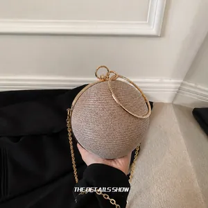 Detail of champagne rhinestone spherical evening bag with golden ring handle and chain