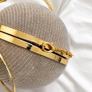 Detailed close-up of champagne gold spherical evening bag with glitter texture and chain