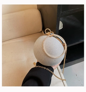 Sparkly silver spherical clutch bag with golden metal ring handle and rhinestone detail