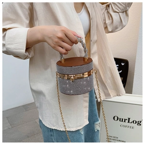 Gedetailleerd beeld van luxe strass emmertas met kristallen handvat en gouden ketting