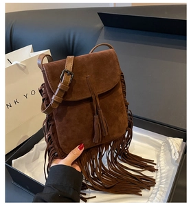 Detail van donkerbruine suède crossbodytas met franjes in een luxe geschenkverpakking