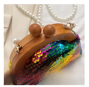 Close-up of shell clutch bag with rainbow sequins, wooden frame, and pearl charms