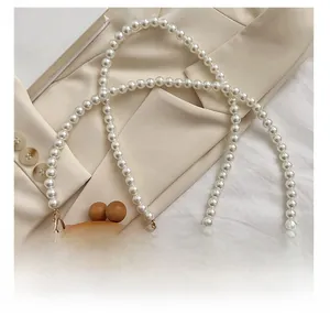 Detail of pearlescent strap and gradient sequin evening bag with a wooden bead clasp