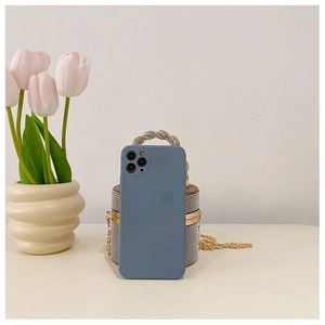 Morandi blauwe matte telefoonhoes naast een luxe cilindrische emmerstas met stras