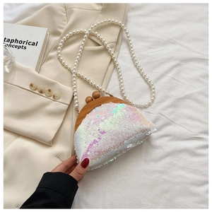 Detailed macro view of sequin clutch bag with wood frame and elegant pearl chain strap