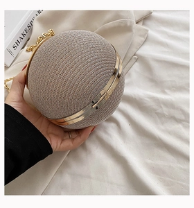 Detail of champagne spherical evening bag with rhinestones and gold ring handle