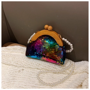 Detail of sequin evening clutch with wooden frame closure and elegant pearl chain strap