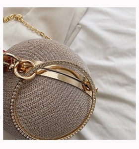 Macro shot of sparkling champagne ball clutch with rhinestones and metal ring handle