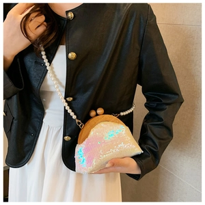 Detail of sequin shell evening bag with pearl chain strap and wooden bead closure