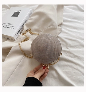 Detail of champagne spherical glitter evening bag with gold ring handle and chain