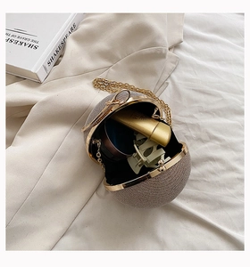 Detail of opened champagne sparkling ball evening bag showing internal capacity with makeup