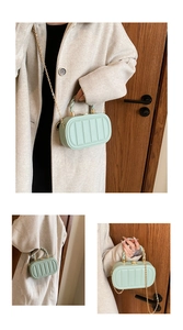 Detail of mint green acrylic handbag with twisted handle and gold chain strap