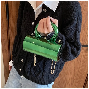 Close-up of green metallic acrylic box bag with mirror finish and golden chain