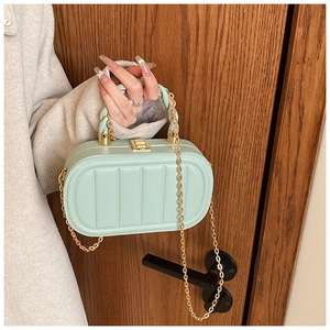 Détail du sac rigide en acrylique vert menthe avec poignée torsadée et fermoir doré