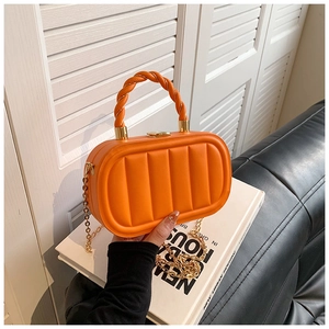 Détail du mini sac matelassé orange avec poignée torsadée et bandoulière dorée