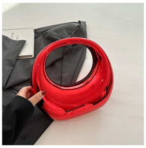 Macro shot of luxury red acrylic crescent bag with glossy mirror finish on grey suit