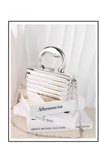 Detail of silver mirror metallic evening clutch featuring modern horizontal grooves and chain