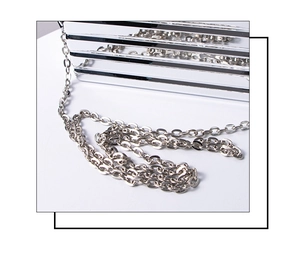 Detailed view of silver metallic mini bag featuring horizontal stripes and slim chain