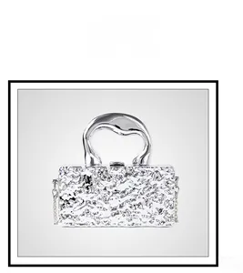 Detail of silver liquid metal texture and futuristic handle on mini chain bag