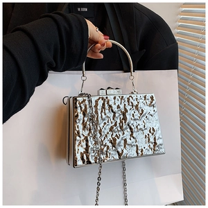 Detail of silver metallic fluid ripple texture acrylic clutch bag with metal ring handle