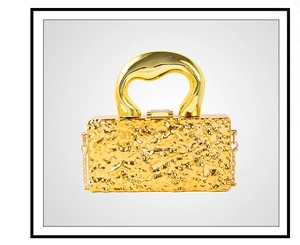 Detail of gold metal crossbody bag with lava texture surface and artistic chunky handle