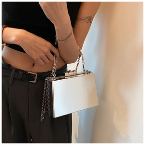 Detail of silver mirror acrylic evening box bag with metallic latch and chain strap