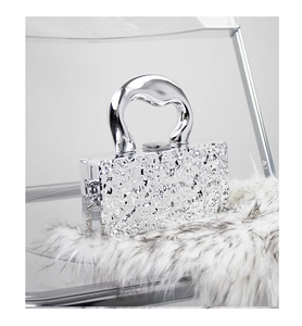 Detailed view of silver lava-textured chain bag with liquid metal finish on plush fabric
