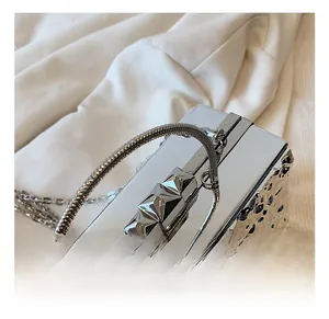 Detail of silver metallic evening bag with geometric cutouts and snake chain handle