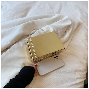 Golden square hard shell evening clutch bag shown next to a smartphone for size reference