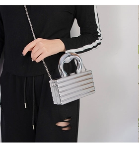 Detail of silver metallic mini bag with ribbed texture, metal handle and chain strap