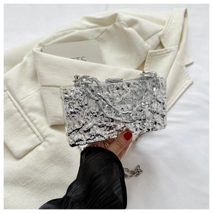 Detailed view of silver crinkle-textured metallic clutch bag with chunky chain strap