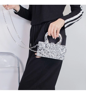 Detail of silver metallic crossbody bag featuring wrinkled texture and round handle