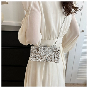 Silver metallic box clutch with lava texture showing the chain strap on model's back