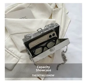Silver square box bag showing capacity for a smartphone and sunglasses inside