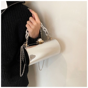 Close-up of silver mirror cylinder clutch with pearl clasp and chunky chain handle